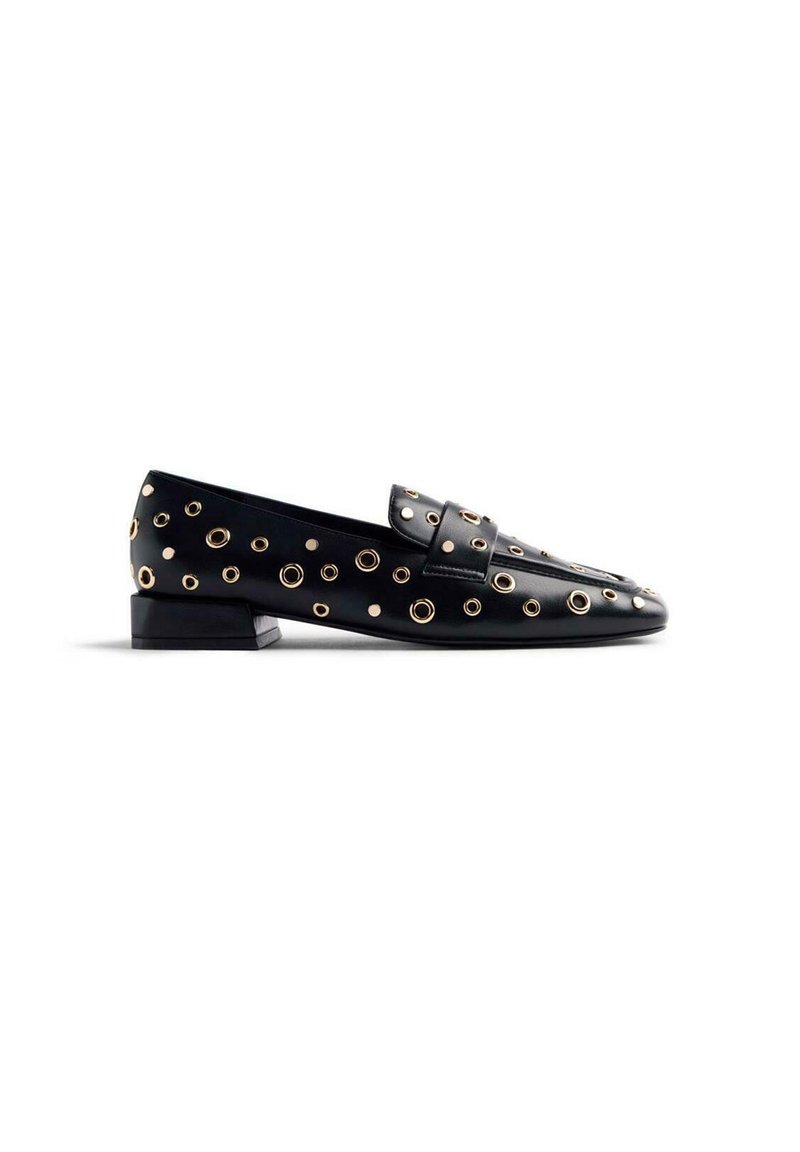 Mocasines de cuero negro con acentos de ojales en tono dorado, tacón plano y un diseño estructurado para un look moderno.
