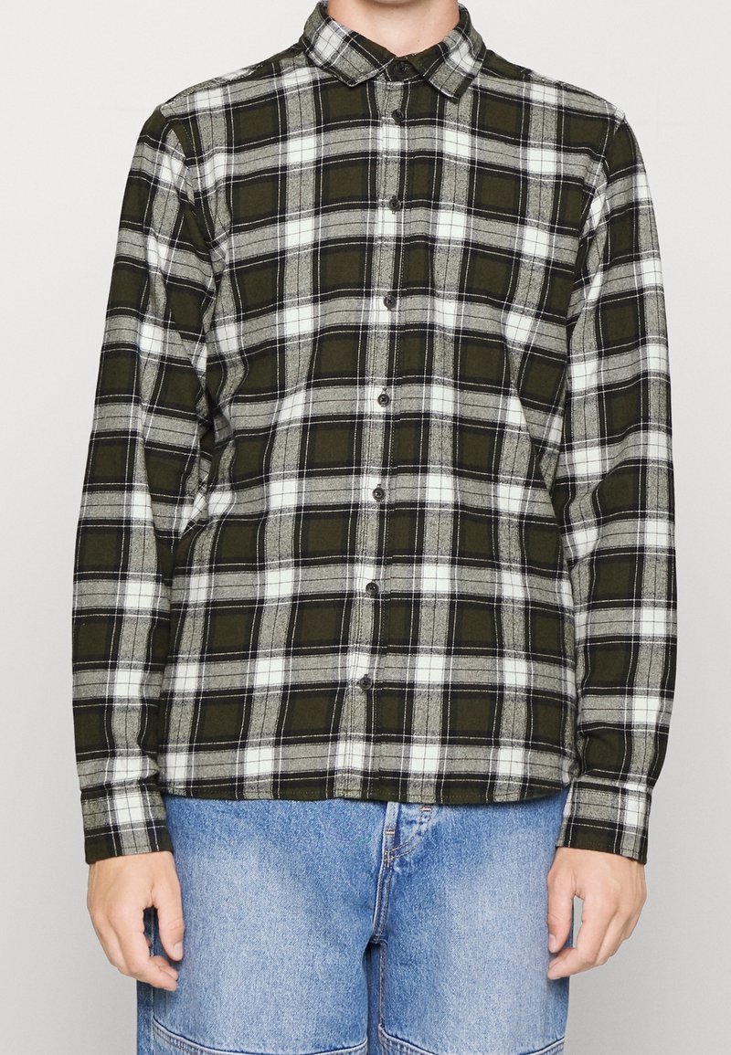 Zeleno-šedá kostičkovaná flanelová košile s knoflíkovým zapínáním vpředu, dlouhými rukávy a límcem. Měkká textura s kontrastními bílými pruhy.