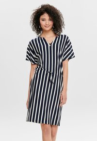Vestido riscado em azul marinho e branco, com decote em V, mangas curtas, cinto na cintura e um corte descontraído. Feito de um material suave e leve.