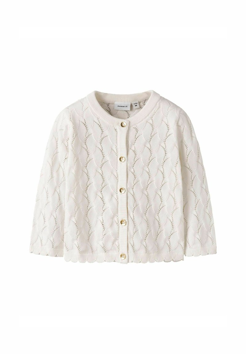 Cardigan pour bébé en tricot blanc avec un motif en vagues, boutons dorés sur le devant, et bords côtelés au col, aux poignets et à l'ourlet.