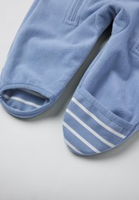 Lichtblauwe fleece broek met open voeten; gestreepte lichtblauwe en witte accenten aan de onderkant. Zachte textuur, casual ontwerp.
