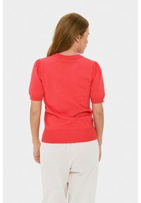 Maglione corto a maniche corte di colore corallo con maniche a palloncino, orlo a costine e scollatura rotonda. Tessuto a maglia morbido, design minimalista senza motivi visibili.