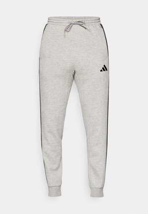 Szare dresy z elastycznym paskiem na wyciąg oraz sznurkiem, zwężanymi nogawkami, czarnymi paskami po bokach i czarnym logo Adidas z przodu.