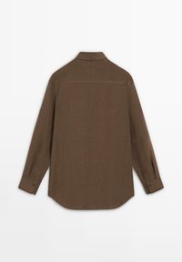 Chemise marron à manches longues boutonnée, vue de dos avec un col et des poignets boutonnés sur un fond blanc uni.