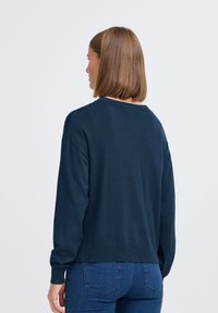 Maglione in maglia blu navy con una vestibilità rilassata, colletto rotondo e maniche lunghe. Presenta polsini e orlo a costine. Texture liscia.