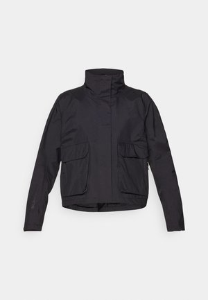 Jachetă cropped neagră, cu un guler înalt, două buzunare frontale și un material ușor, neted. Design minimalist fără închideri vizibile.