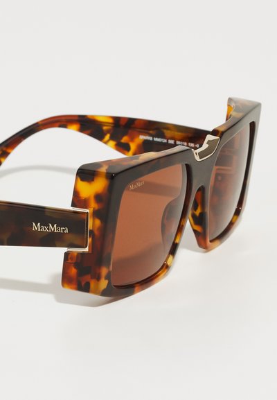 Żółwie okulary przeciwsłoneczne o kwadratowych oprawkach, brązowych soczewkach i złotych akcentach z logo MaxMara na zausznikach.