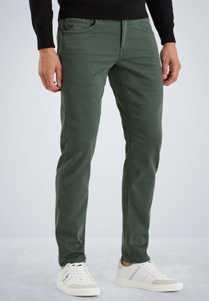 Green cotton blend jeans with a slim fit, featuring five pockets, and subtle stitching. Paired with white sneakers.