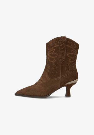 Braune Wildleder-Ankle-Boots mit spitzem Zehenbereich, dekorativen Nähten und einem mittelgroßen Absatz, der mit einem metallischen Detail akzentuiert ist.