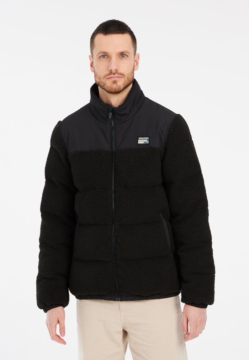 Sort fleece puffer-jakke med lynlås, der har en glat sort øverste del og en tekstureret nederste del. Ribbet manchetter og talje medfølger.