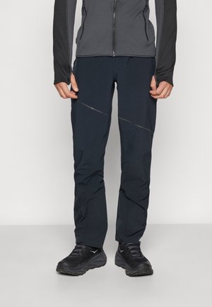Zwarte, lichte buitenbroek met een slim fit, voorzien van een subtiele glans en diagonale naadaccenten. Materiaal lijkt ademend en duurzaam te zijn.