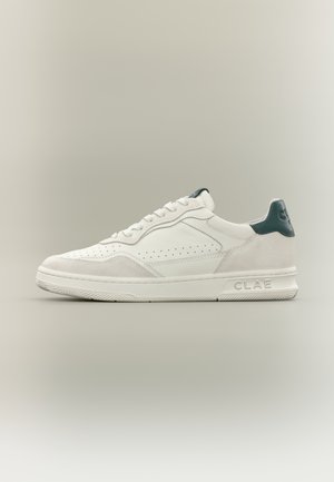 Hvid lavtop-sneaker med ruskind og læderpaneler, perforeret side, sort hælkappe og præget "CLAE"-mærkning på sålen.