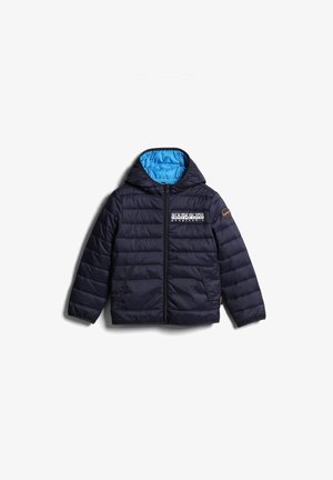 Bambino con giacca puffer blu navy, felpa con grafica, pantaloni jogger abbinati, sneaker nere e una borsa nera a tracolla su una spalla.