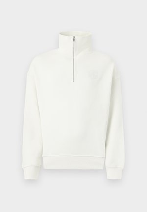 Valge pika varrukaga dressipluus kõrge krae ja eespool poole luku, sooniku mansettide ja äärega, esitletud ühtsel heledal taustal.