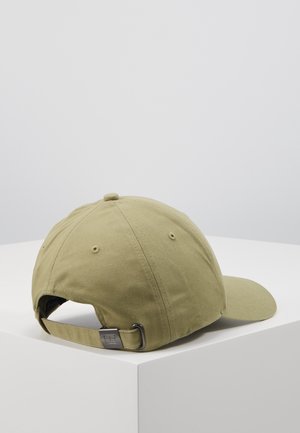 Jasno oliwkowa czapka bejsbolowa z regulowanym materiałowym paskiem i metalową klamrą, leżąca na białej powierzchni z narożnikami.