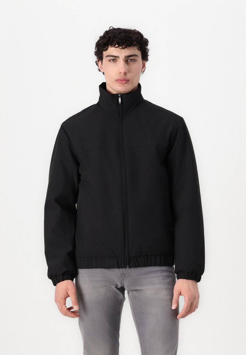 Sort lynlåsjakke med ståkrave, elastiske manchetter og talje. Glat, tekstureret stof; minimalistisk design, ingen synlige mønstre eller accenter.