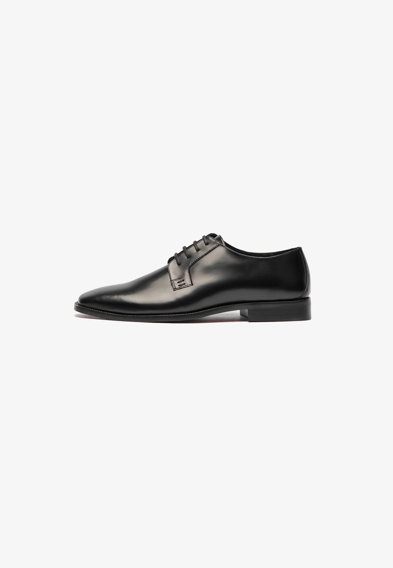 Črne usnjene oblečne čevlje s sleek obliko, koničastim nosom in petimi luknjami za vezalke. Gladka tekstura in minimalno šivanje. Guma podplat.