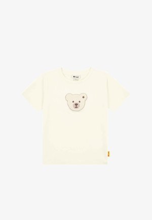 Cream cotton t-shirt featuring a plush bear face appliqué on the front. Short sleeves and a tag at the hem. Smooth texture.