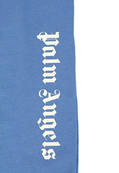 Tessuto blu con bold testo bianco "Palm Angels" in un font stilizzato, allineato verticalmente sul lato sinistro. Texture morbida e design casual.
