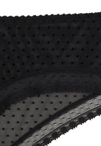 Tissu noir transparent avec motif à pois, bordure en dentelle festonnée et texture lisse. Présente des accents délicats le long des bords.