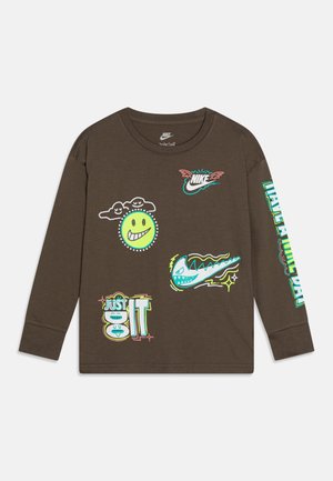 Brązowa koszula z długim rękawem z kolorowymi logo Nike, uśmiechniętą zieloną buźką z chmurami i napisem "Just Do It" na przodzie i na prawym rękawie.