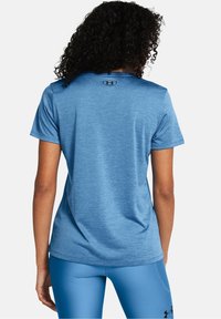Niebieska sportowa koszulka z krótkim rękawem, wykonana z teksturowanej tkaniny, z okrągłym dekoltem i małym logo z tyłu.