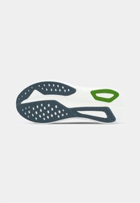 White shoe sole with black and green textured tread patterns and ventilation holes on a plain light background.