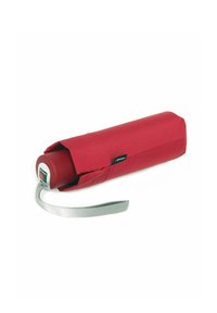 Red compact umbrella with a cylindrical shape, features a gray fabric strap, and a plastic grip with a button for opening and closing.