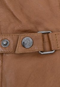 Brauner Ledergürtel mit einer silbernen Metallschnalle und Druckknopfverschluss. Enthält genähte Verzierungen und ein rundes Logo-Element.