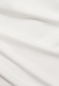 Textilstoff in Weiß, mit einer glatten Textur und leichten Falten, der eine weiche, leichte Qualität zeigt.