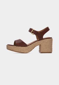 Sandale en cuir marron à bout ouvert avec bride de cheville et boucle dorée, avec une semelle plateforme tressée et un talon bloc.