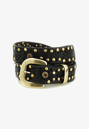 Cintura in pelle nera con motivi floreali in rilievo, borchie dorate e fibbia in ottone, arrotolata su uno sfondo bianco.