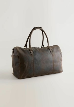 Ruskea nahkainen matkalaukku, jossa on kaksi pyöreää kahvaa, vetoketjukiinnitys, sivutasku, sileä pinta, suorakaiteen muotoinen ja näkyvät ompeluyksityiskohdat.