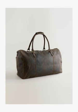 Ruskea nahkainen matkalaukku, jossa on kaksi pyöreää kahvaa, vetoketjukiinnitys, sivutasku, sileä pinta, suorakaiteen muotoinen ja näkyvät ompeluyksityiskohdat.