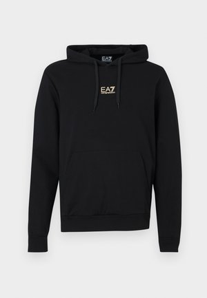 Melns kapuci džemperis no mīksta auduma ar priekšā esošu kengūra kabatu, ribotu aproci un zelta EA7 logotipu uz krūtīm.