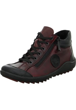 Botte de cheville en cuir rouge avec accents noirs, fermeture à lacets et zip latéral, semelle en caoutchouc texturé, bout rond et détail de logo circulaire.