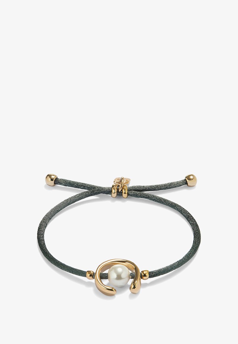 Bracelet avec un cordon gris foncé, un accent en métal doré avec un design en boucle, et une perle blanche au centre. Fermeture par nœud ajustable.