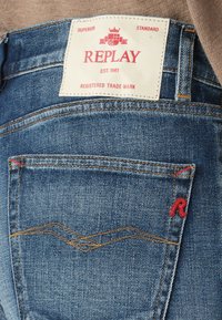 Jeans dżinsowe w jasnoniebieskim kolorze, proste dopasowanie, wzmocnione szwy oraz charakterystyczne czerwone logo "R" na tylnej kieszeni.