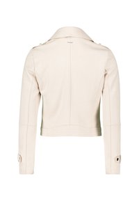 Giacca beige, corta, con colletto classico, maniche lunghe e polsini con bottoni. Presenta cuciture a vista e una trama liscia.