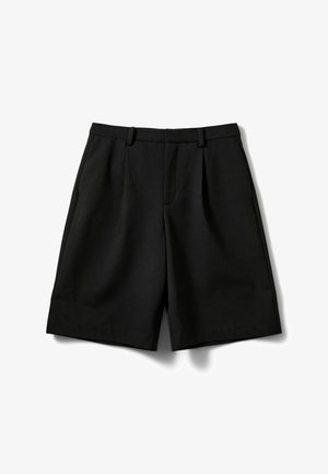 Pantalones cortos negros con un diseño a medida, que presentan pliegues, una textura suave y un corte de longitud media. Sin herrajes ni adornos visibles.