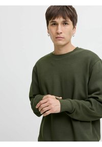 Olijfgroene sweatshirt met ronde hals, ribgebreide manchetten en een relaxte pasvorm. Gladde textuur met zichtbare stikseldetails.