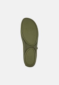Suela de zapato color verde oliva con goma texturizada, presenta letras grabadas "PER" y tamaño "38", forma redondeada y bordes cosidos.