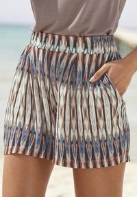 Multicolore, gemusterde shorts met een elastische tailleband, voorzien van abstracte lijnen in crèmekleurige, blauwe en roestkleurige tinten, en zijzakken.