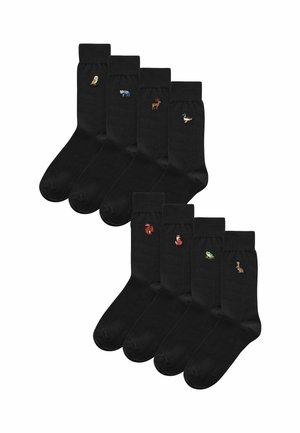 Schwarze Socken mit gestickten Tiermotiven: eine Eule, ein Fisch, ein Reh, eine Ente, ein Eichhörnchen, ein Fuchs, ein Frosch und ein Kaninchen in zwei Reihen.
