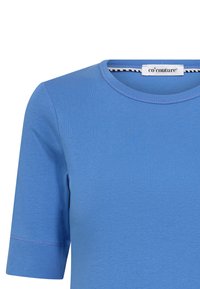 T-shirt azzurro a maniche corte realizzato in morbido cotone. Presenta un colletto rotondo e una texture a coste con cuciture visibili sulle maniche. Etichetta con logo attaccata.