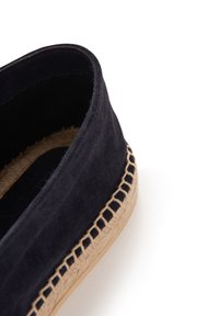 Espadrilles in suede blu navy con suola in juta intrecciata e dettagli di cucitura intricati lungo il bordo, che mostrano un design basso e arrotondato.