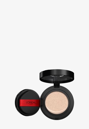 Compact de fond de teint cushion L’Oréal avec un boîtier circulaire noir et une touche rouge ; contient un coussin doux beige pour l'application.
