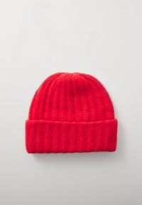 Red knitted beanie hat with a ribbed texture, featuring a folded cuff and soft, warm material. Round shape, designed for cold weather wear.