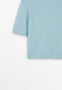 Maglione azzurro chiaro a maniche corte in maglia, con scollo rotondo, bordi a coste su polsini e orlo, tessuto liscio e design semplice.
