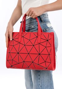 Borsa geometrica rossa in materiale sintetico, con un motivo triangolare contornato di nero, dotata di due manici corti.